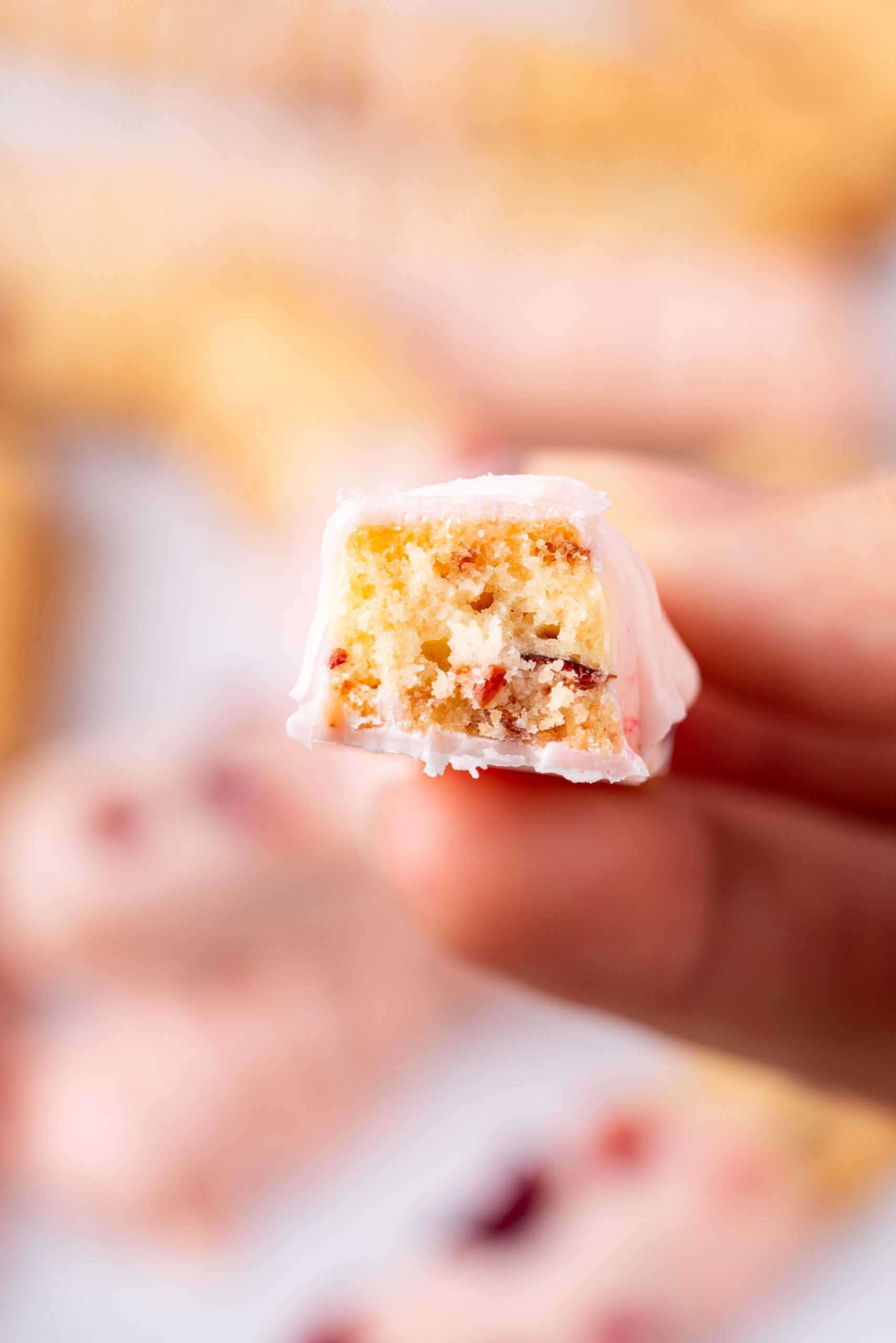 Close-up of a Cranberry Cookie with a bite taken, showing buttery inside with cranberries and white chocolate coating.