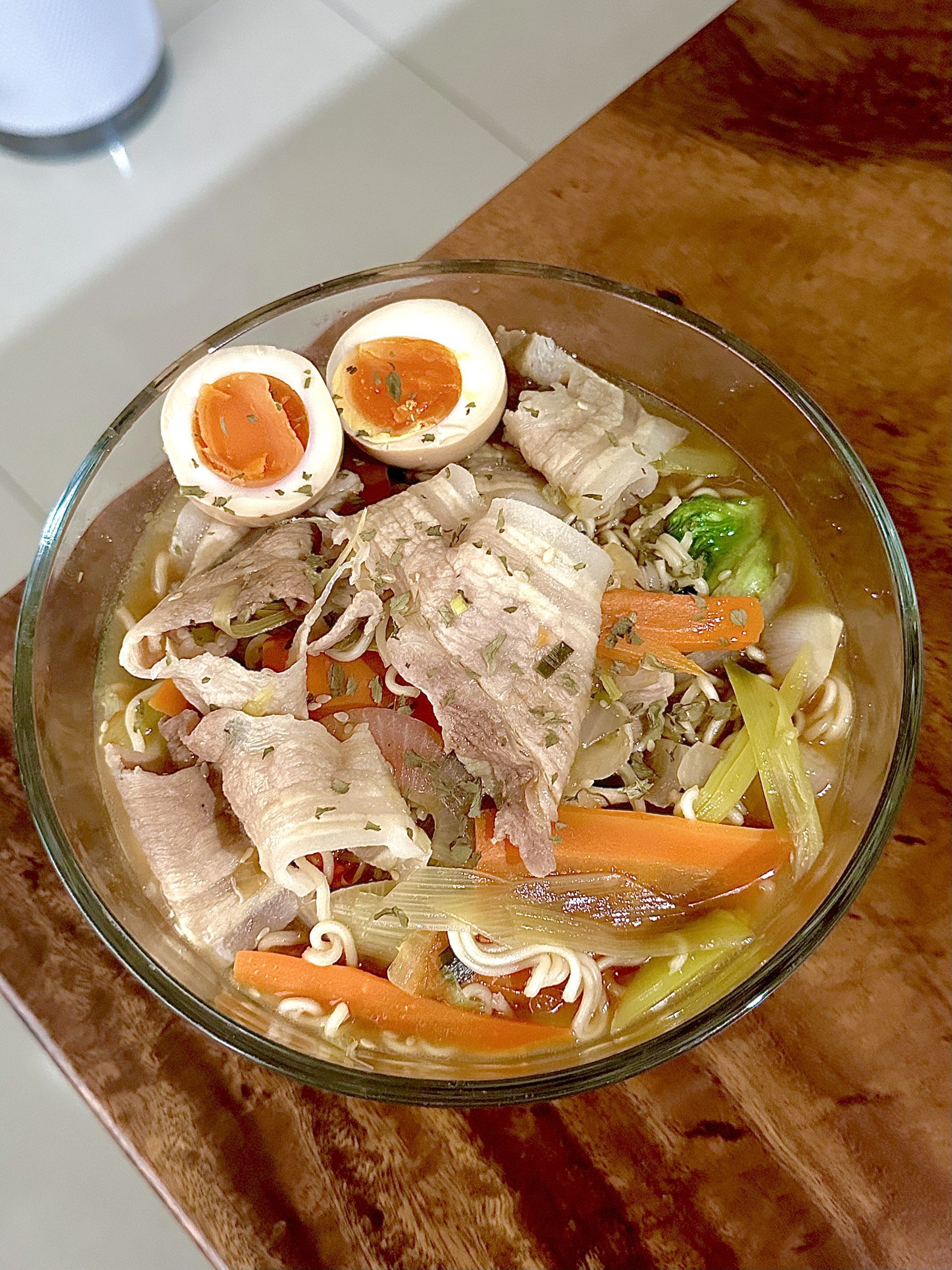 Korean Marinated Eggs (Mayak Gyeran) served over a bowl of ramen with pork slices, carrots, and vegetables in savory broth. Ramen Noodle cooked with Korean Egg Marinade
