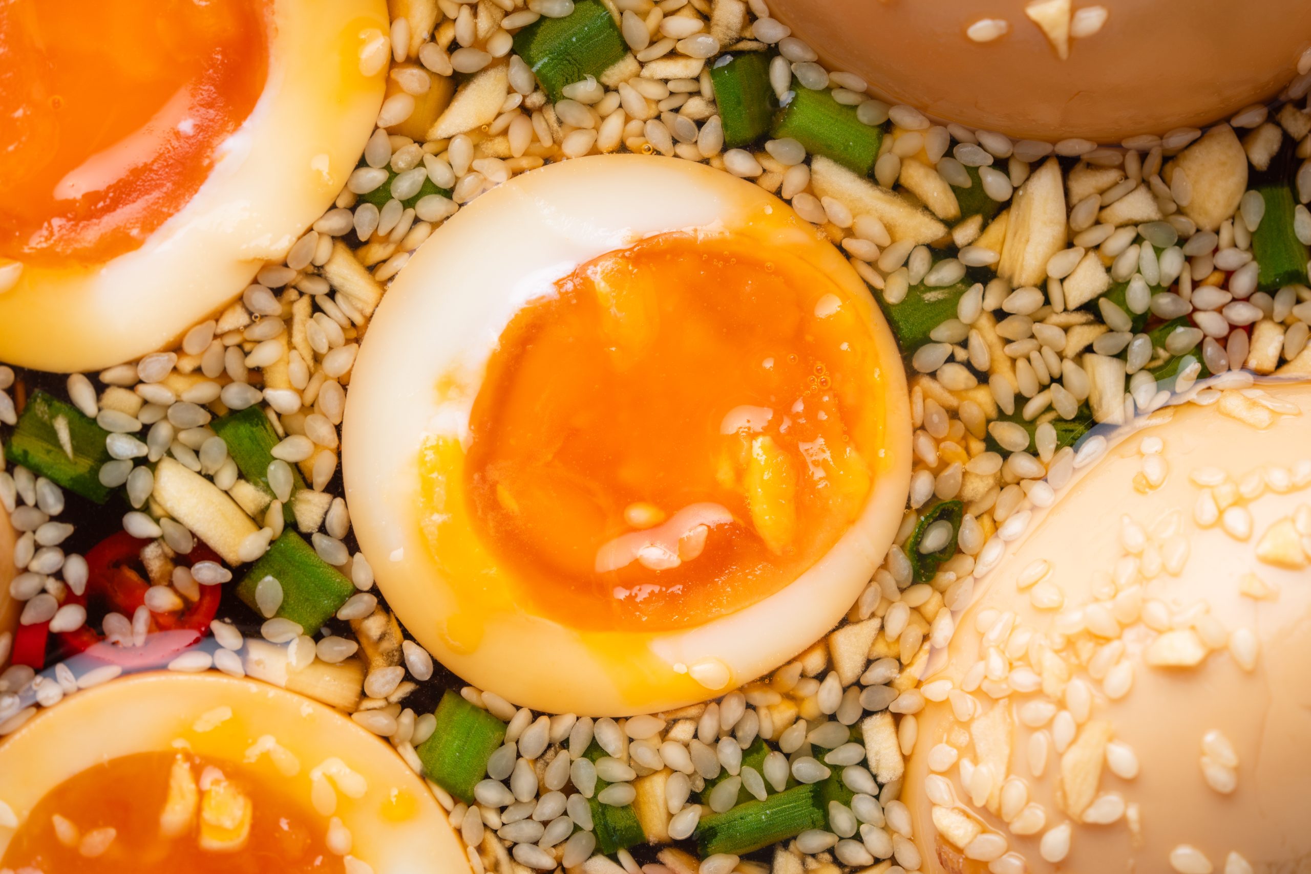 Korean Marinated Egg cut in half with golden yolk inside soy, sesame, garlic, and scallion marinade