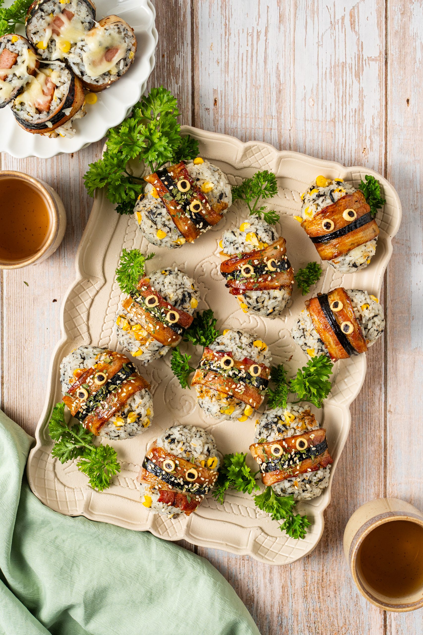 Top-down view of bacon-wrapped rice balls served as a party appetizer with tea cups