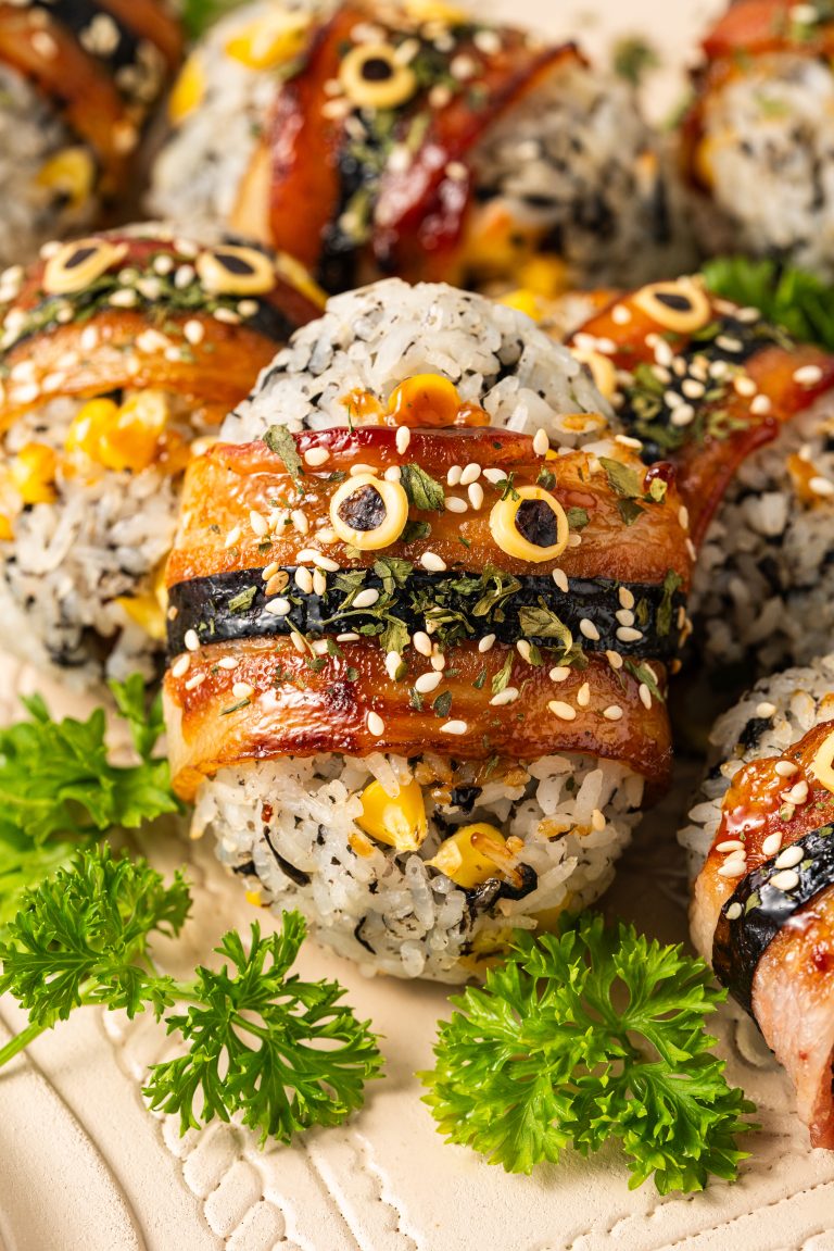 Close-up of Japanese-style bacon-wrapped rice balls garnished with parsley and sesame seeds