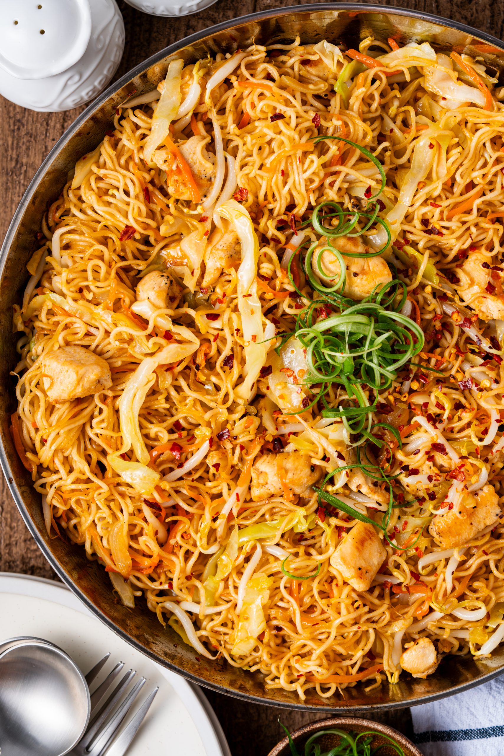Homemade ramen noodle stir fry with chicken and vegetables garnished with green onions