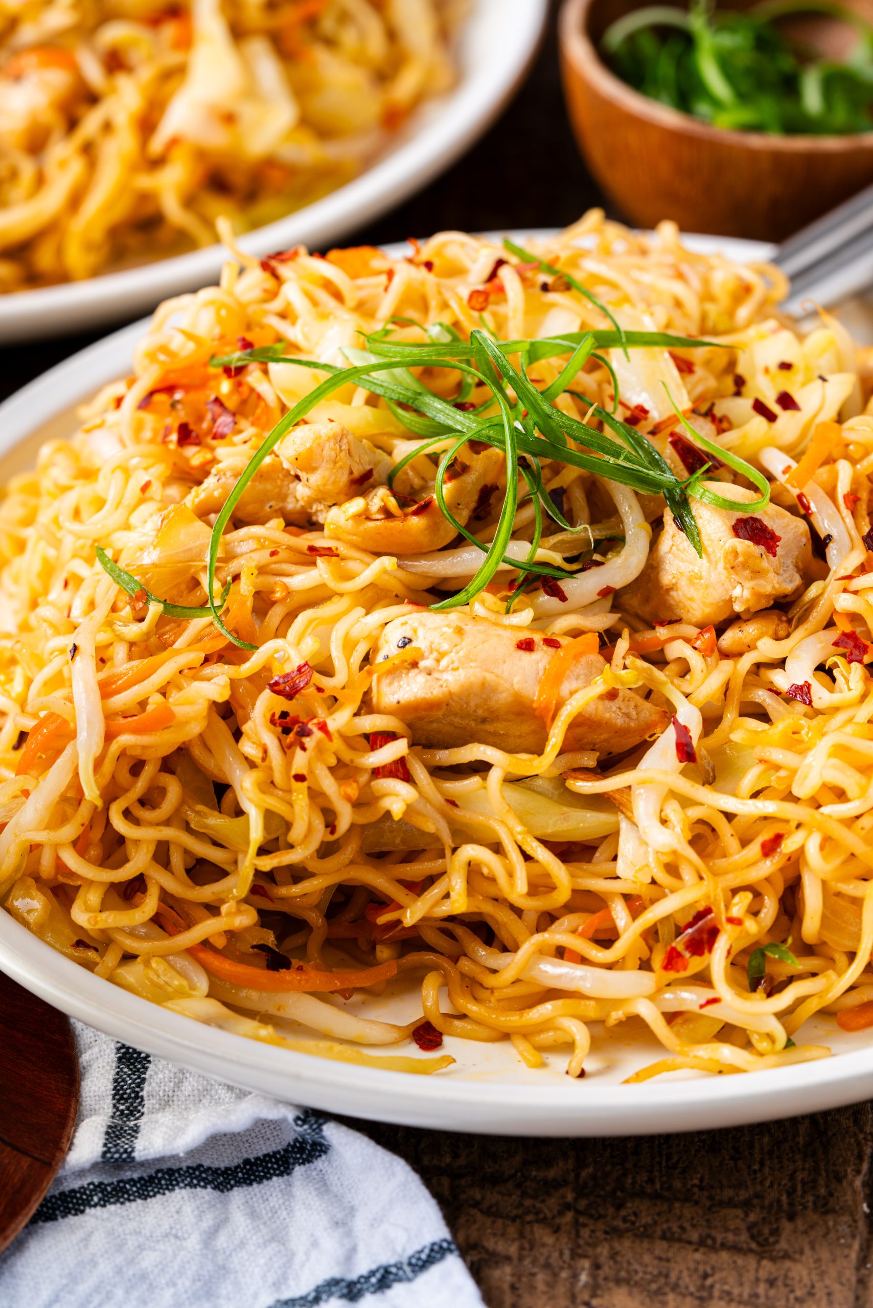 Spicy chicken ramen noodles with cabbage, carrots, and chili flakes in a savory stir fry