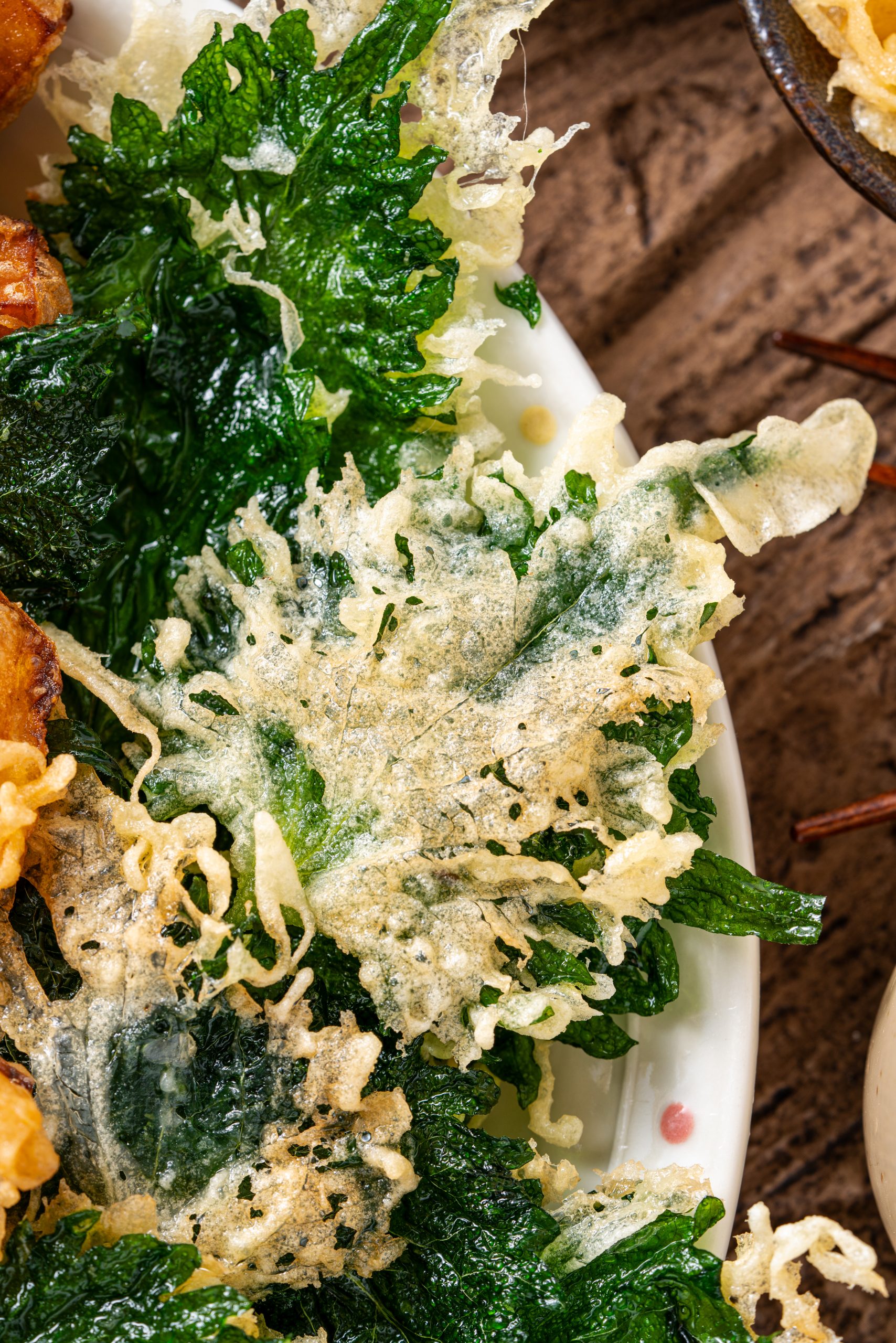 Close-up of shiso leaf tempura, lightly battered and fried until golden and crunchy.